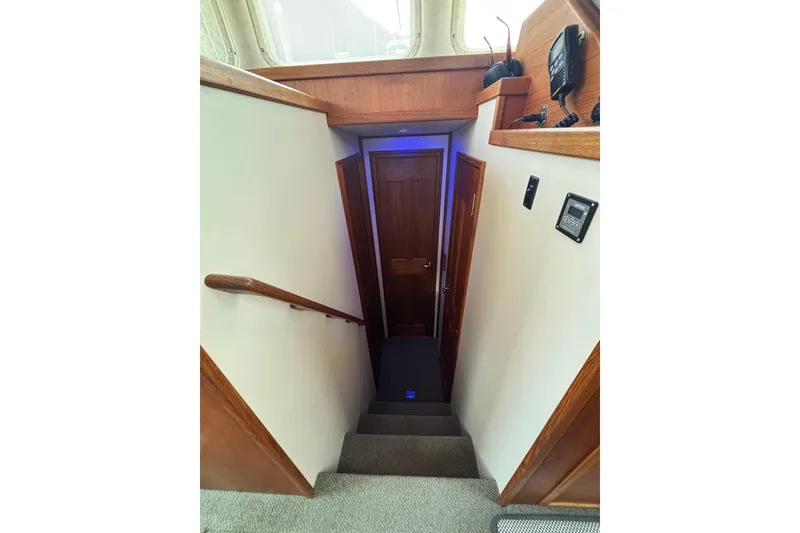 Slide: The Image of Stairway inside 2004 Nordic Tug 37, featuring wooden accents and modern controls. - 20