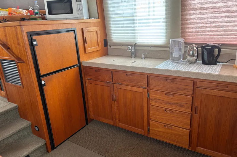 Slide: The Image of 2004 Nordic Tug 37 galley with wooden cabinets, countertop, and appliances. - 9