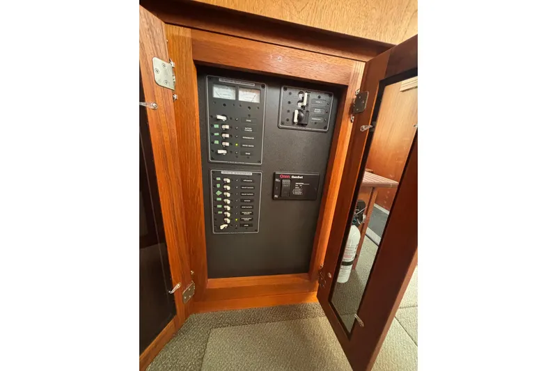 Slide: The Image of Electrical panel inside a 2004 Nordic Tug 37 boat, featuring circuit breakers and controls. - 7