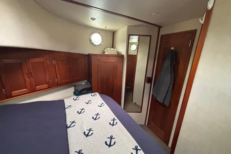Slide: The Image of Cozy cabin interior of 2004 Nordic Tug 37 with nautical-themed bedding and wooden cabinetry. - 19