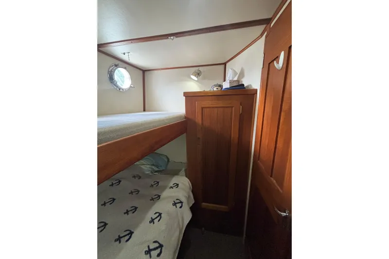 Slide: The Image of Cozy cabin interior of 2004 Nordic Tug 37 with bunk beds and wooden cabinetry. - 14