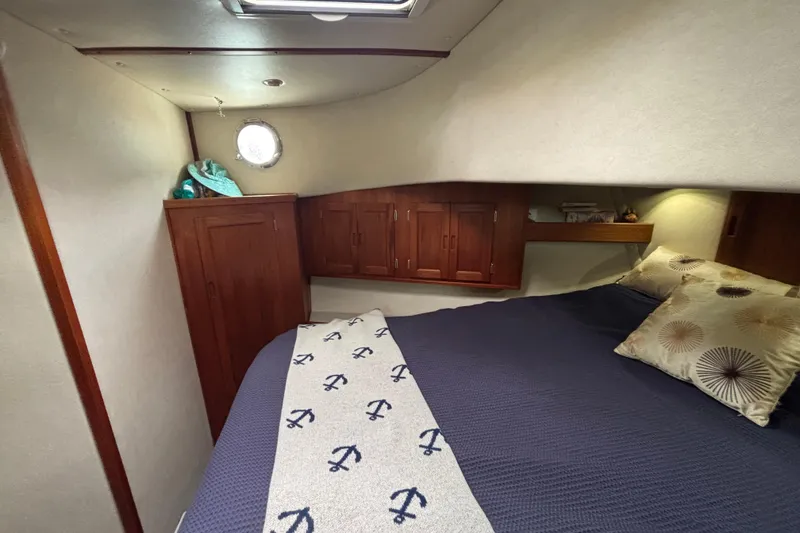 Slide: The Image of Cozy cabin interior of 2004 Nordic Tug 37 with nautical-themed bedding and wooden cabinetry. - 18