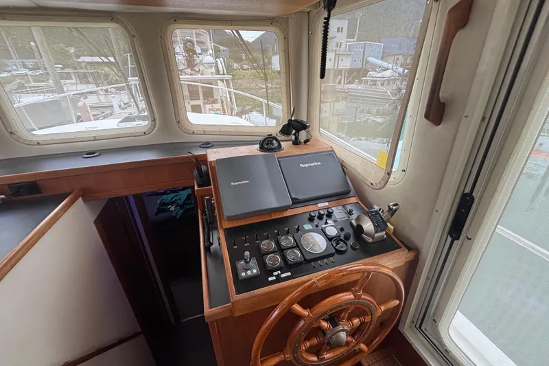 Slide: The Image of Pilothouse of 2004 Nordic Tug 37 with navigation equipment and wooden steering wheel. - 5
