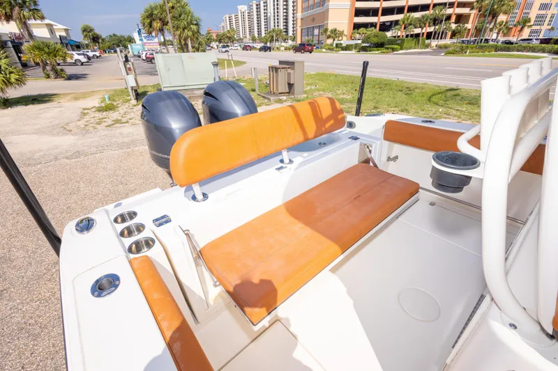 Slide: The Image of 2017 Cobia 261 Center Console boat with orange seating and dual engines, parked near a road. - 42