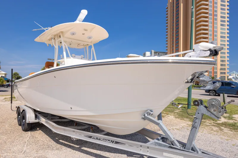 Slide: The Image of 2017 Cobia 261 Center Console boat on trailer, urban backdrop, clear sky. - 9