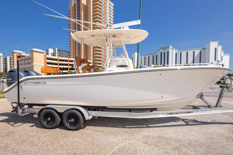Slide: The Image of 2017 Cobia 261 Center Console boat on trailer, urban backdrop. - 11
