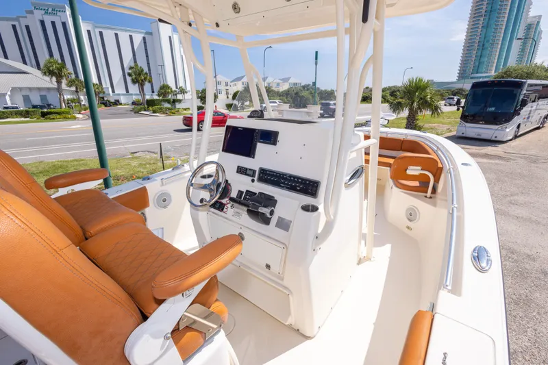 Slide: The Image of 2017 Cobia 261 Center Console boat with tan seating and modern dashboard. - 21
