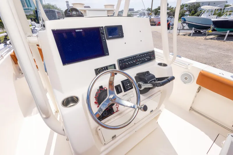 Slide: The Image of 2017 Cobia 261 Center Console boat dashboard with steering wheel and navigation screens. - 23