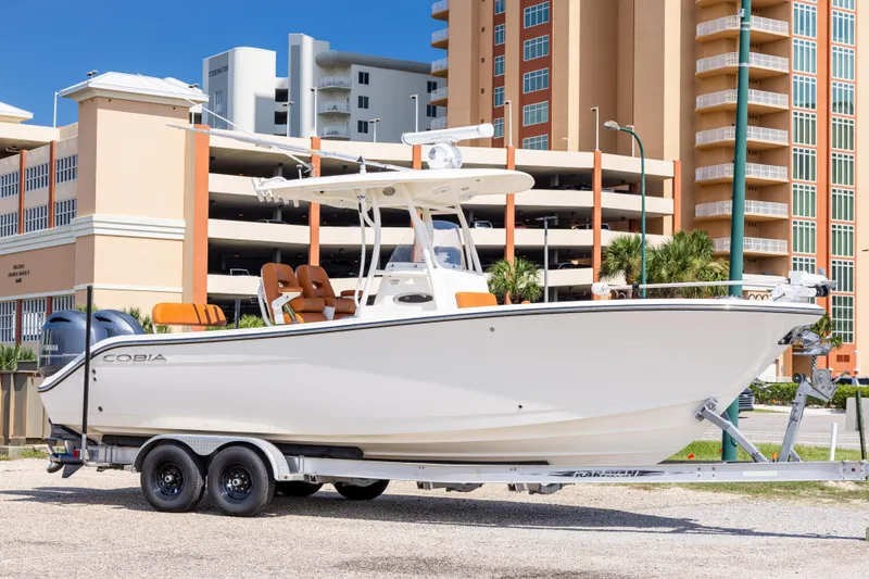 The Image of 2017 Cobia 261 Center Console boat on trailer, urban background. - 0