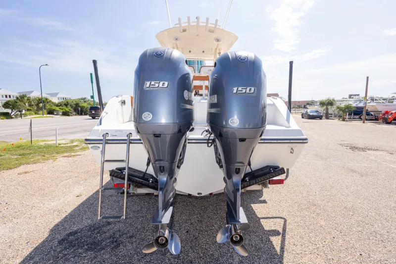 Slide: The Image of 2017 Cobia 261 Center Console with dual Yamaha 150 engines, parked on a sunny day. - 17