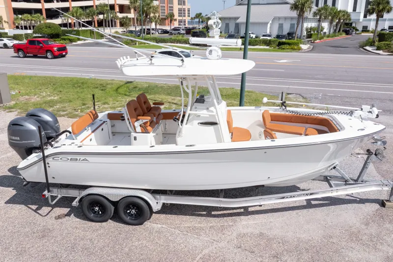 Slide: The Image of 2017 Cobia 261 Center Console boat on trailer, parked near road. - 2