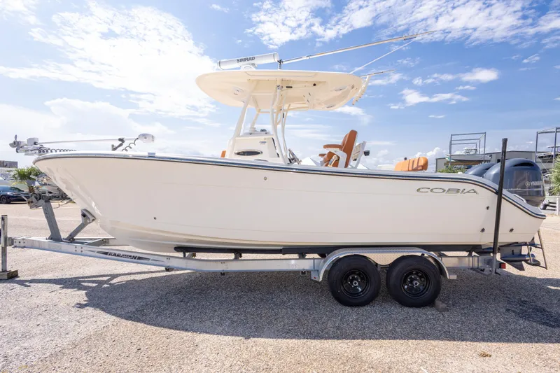 Slide: The Image of 2017 Cobia 261 Center Console boat on trailer under clear blue sky. - 12