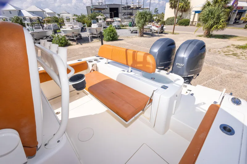 Slide: The Image of 2017 Cobia 261 Center Console boat with dual engines and tan seating in a marina setting. - 41