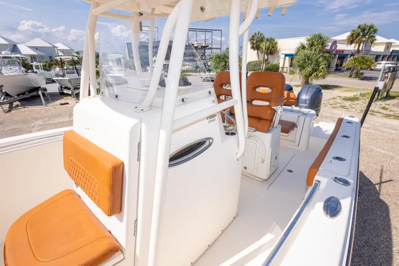 Slide: The Image of 2017 Cobia 261 Center Console boat with tan seating, docked outdoors under clear skies. - 37