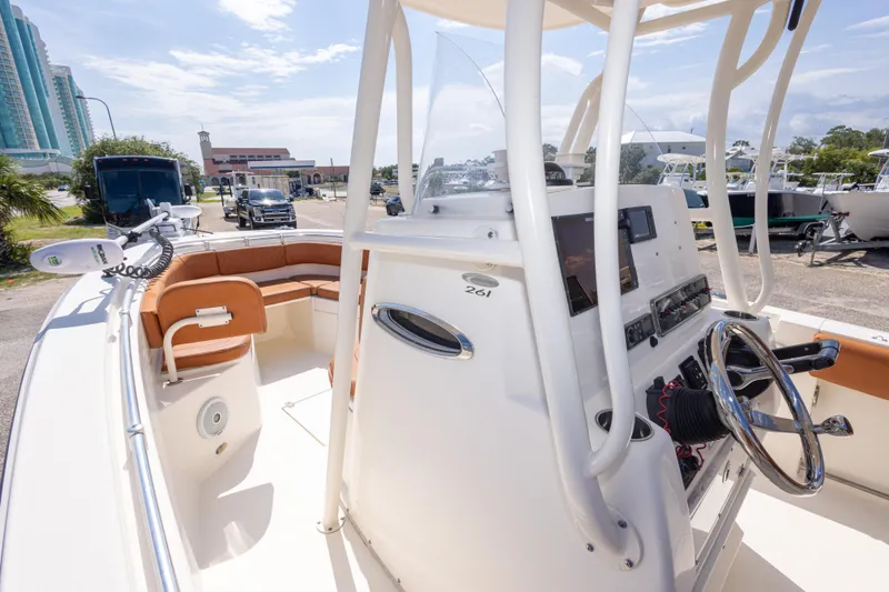 Slide: The Image of 2017 Cobia 261 Center Console boat with modern helm and seating, parked outdoors. - 26