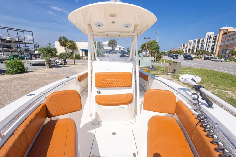 Slide: The Image of 2017 Cobia 261 Center Console boat with orange seating, parked near a coastal road. - 31