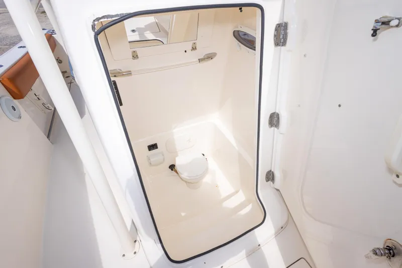 Slide: The Image of 2017 Cobia 261 Center Console boat interior with compact marine toilet. - 32