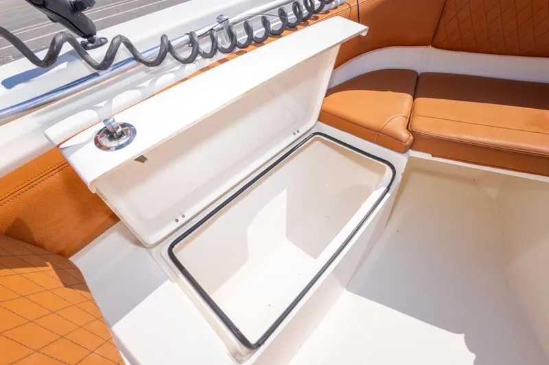 Slide: The Image of 2017 Cobia 261 Center Console boat with open storage compartment and cushioned seating. - 34