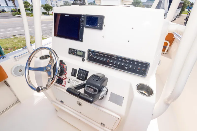 Slide: The Image of 2017 Cobia 261 Center Console helm with steering wheel, controls, and navigation equipment. - 24