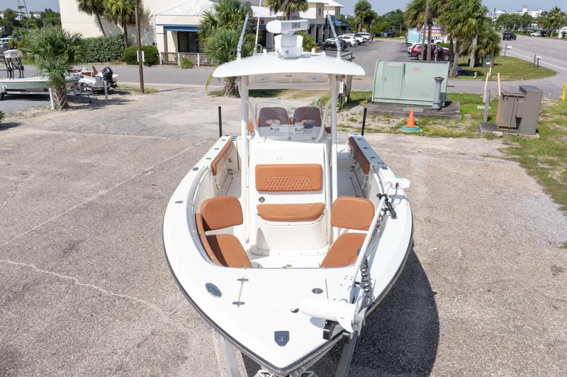 Slide: The Image of 2017 Cobia 261 Center Console boat with tan seating, parked outdoors. - 5