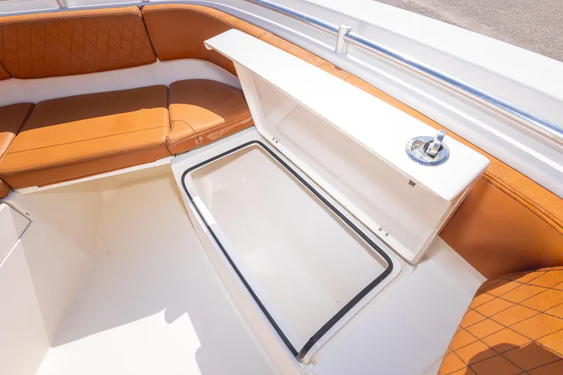 Slide: The Image of 2017 Cobia 261 Center Console boat with tan seating and storage compartment. - 33