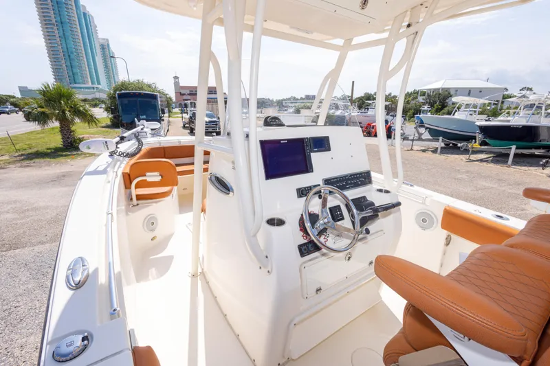 Slide: The Image of 2017 Cobia 261 Center Console boat with modern helm, parked near marina. - 22