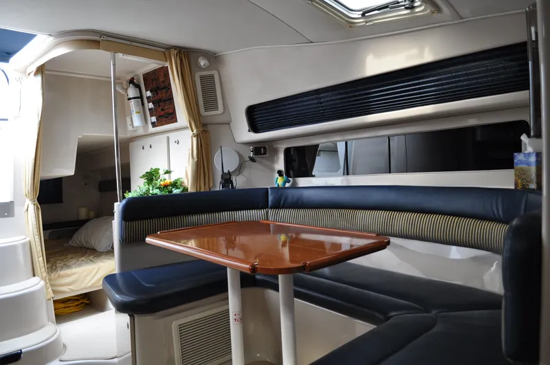 Slide: The Image of Interior of a 1999 Doral 350sc with a sleek wooden table and cushioned seating. - 19