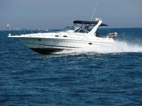 Slide: The Image of A white motorboat speeding across the blue sea, featuring a black canopy. - 1