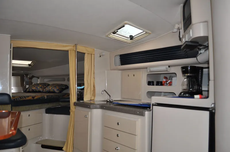 Slide: The Image of Interior of the 1999 Doral 350sc with kitchenette, fridge, and sleeping area. - 21