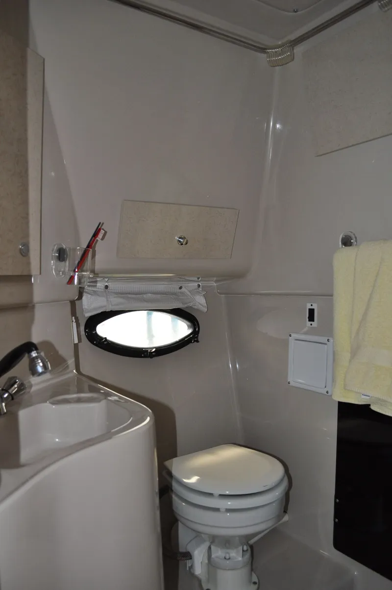 Slide: The Image of The image shows a boat bathroom with a toilet, sink, and porthole. - 23