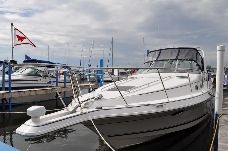 Slide: The Image of A white 1999 Doral 350sc boat docked, featuring a black canopy and sleek design. - 2
