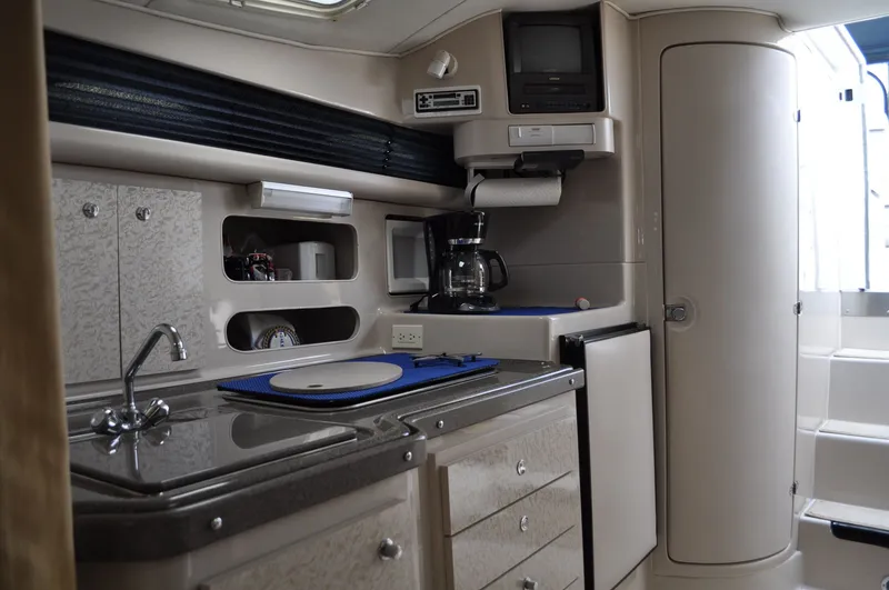 Slide: The Image of The galley of a 1999 Doral 350sc with a sink, refrigerator, and coffee maker. - 20