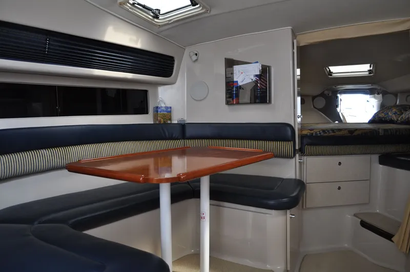 Slide: The Image of Interior of a 1999 Doral 350sc with a table and cushioned seating. - 22