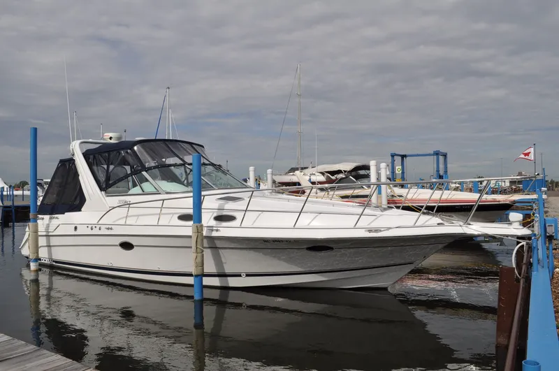 The Image of A white 1999 Doral 350sc boat docked, featuring a black canopy. - 0