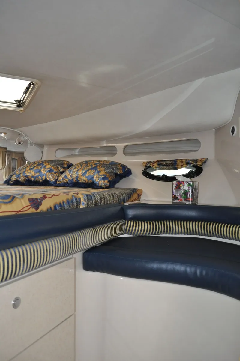 Slide: The Image of The image shows the interior of a 1999 Doral 350sc with blue upholstery and a bed. - 17