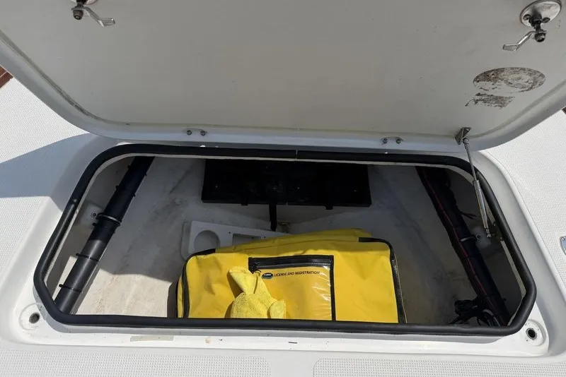 Slide: The Image of Open storage compartment in a 2012 Chaos 16 Bonefish boat with yellow bag inside. - 17