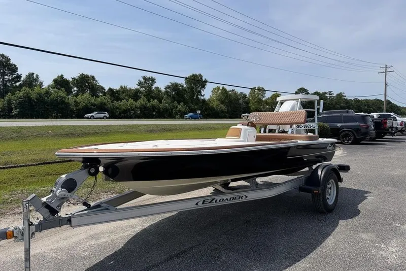 Slide: The Image of 2012 Chaos 16 Bonefish boat on trailer, parked outdoors under clear sky. - 3