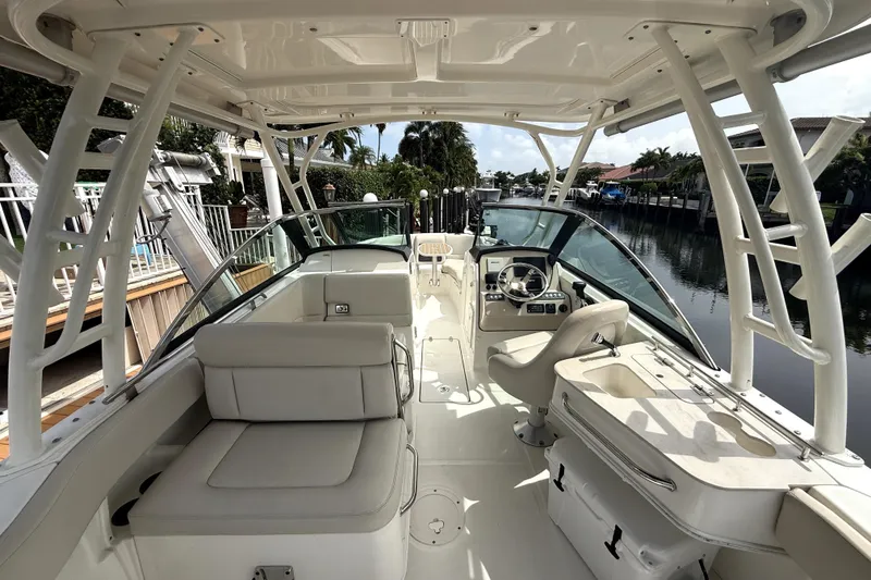 Slide: The Image of 2018 Boston Whaler 230 Vantage boat interior with seating and helm, docked by a canal. - 11