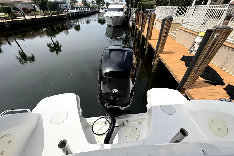 Slide: The Image of 2018 Boston Whaler 230 Vantage docked in a serene canal setting. - 6