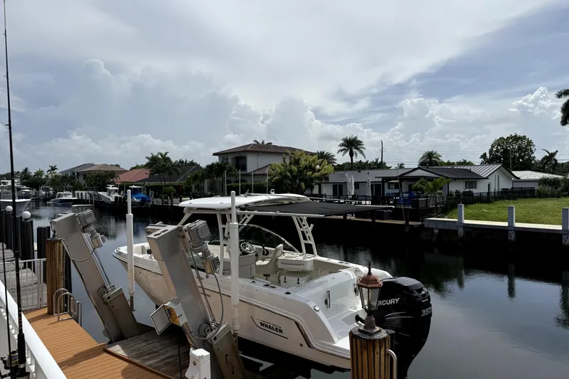 Slide: The Image of 2018 Boston Whaler 230 Vantage docked in a scenic residential canal setting. - 17