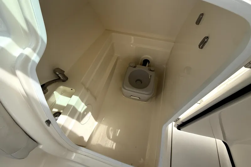 Slide: The Image of Interior of 2018 Boston Whaler 230 Vantage boat showing compact marine toilet. - 9