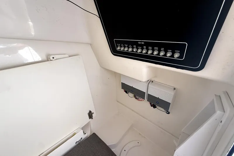 Slide: The Image of Interior view of a 2018 Boston Whaler 230 Vantage boat's control panel and storage area. - 12