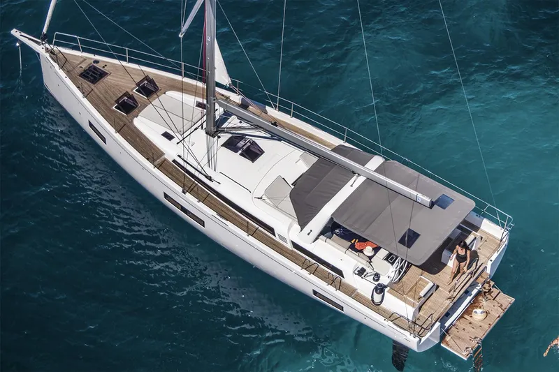 Slide: The Image of Manufacturer Provided Image: 2026 Beneteau Oceanis Yacht 54 sailing on clear blue waters, aerial view. - 1