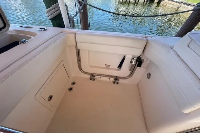 Slide: The Image of 2021 Grady-White Freedom 325 boat interior, featuring spacious seating and storage near the water. - 23