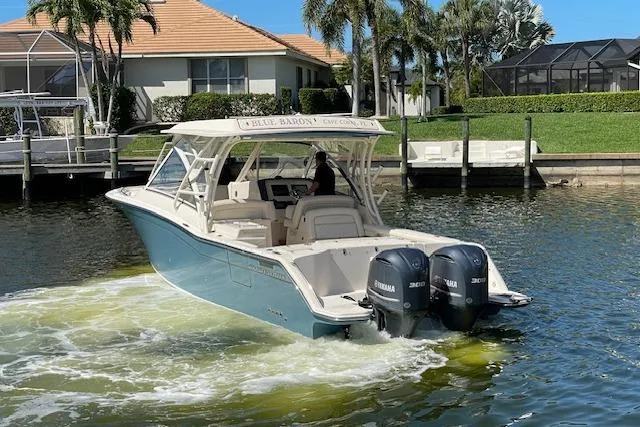 Slide: The Image of 2021 Grady-White Freedom 325 boat cruising in a sunny waterfront setting. - 4