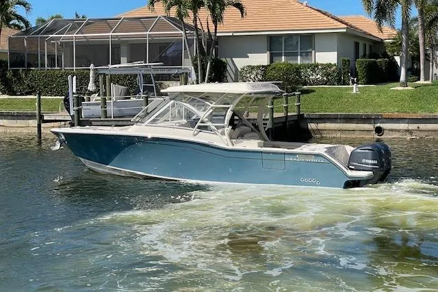 Slide: The Image of 2021 Grady-White Freedom 325 boat cruising in a sunny residential canal. - 6