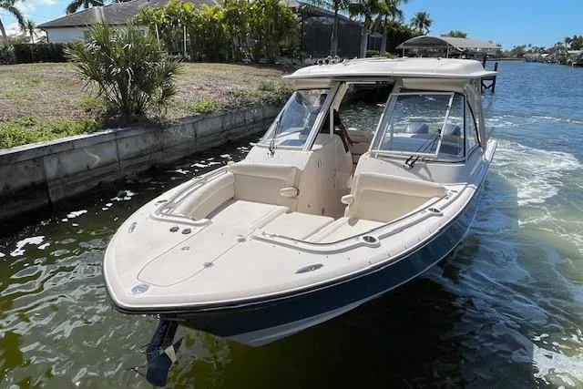 Slide: The Image of 2021 Grady-White Freedom 325 boat on water, near a lush shoreline. - 11