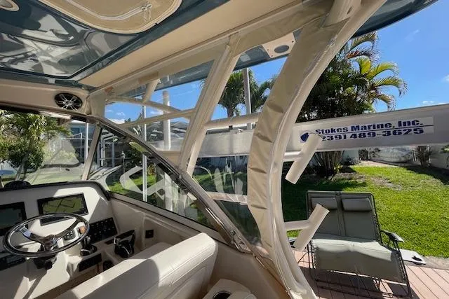 Slide: The Image of 2021 Grady-White Freedom 325 boat interior with steering wheel and dashboard, sunny outdoor setting. - 75