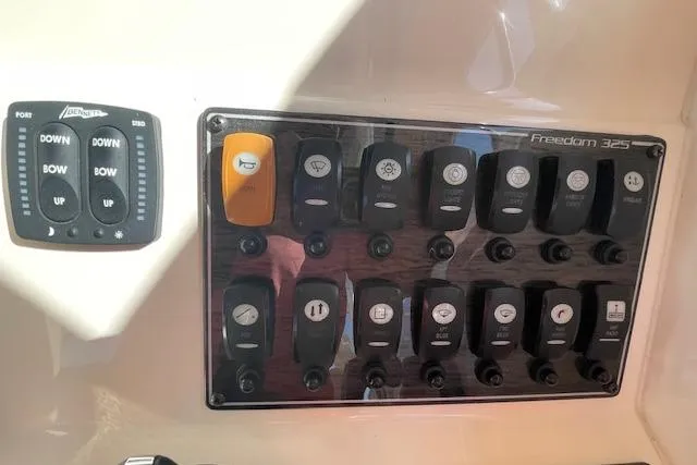 Slide: The Image of Control panel of 2021 Grady-White Freedom 325 boat with various switches and buttons. - 45