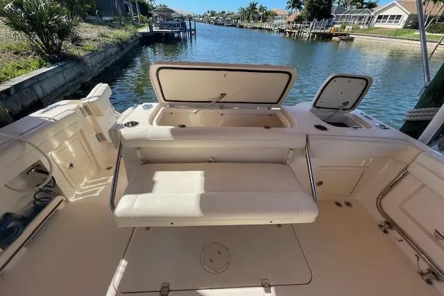 Slide: The Image of 2021 Grady-White Freedom 325 boat interior with open storage compartments by a canal. - 22